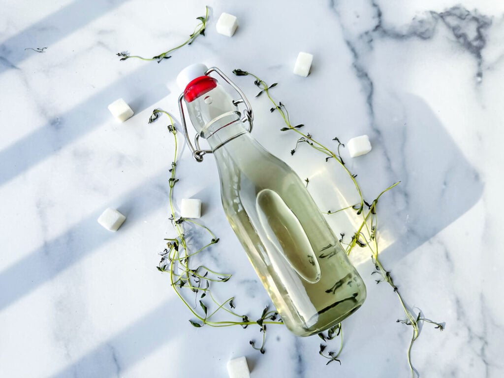 Photo of thyme infused simple syrup in a clean glass jar