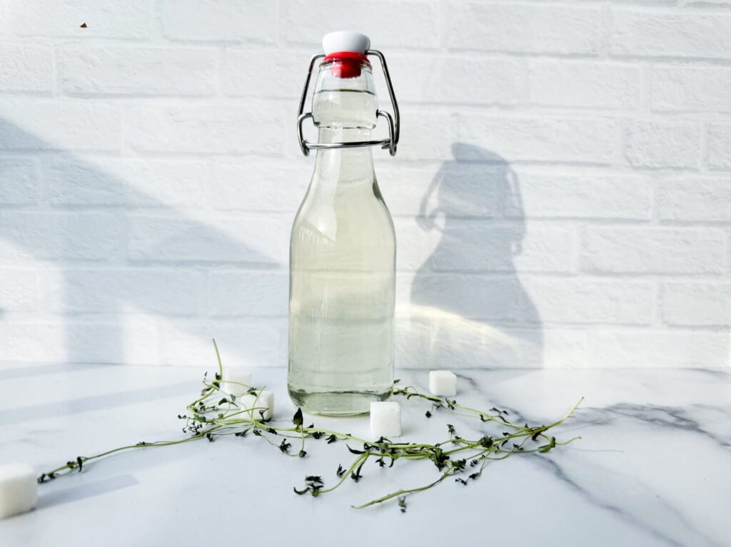 photo of thyme simple syrup in a glass jar