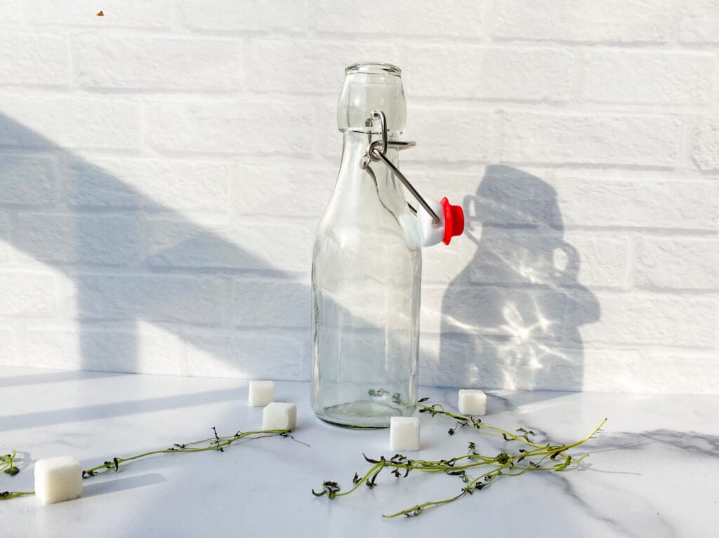 Photo of glass jar next to thyme stems
