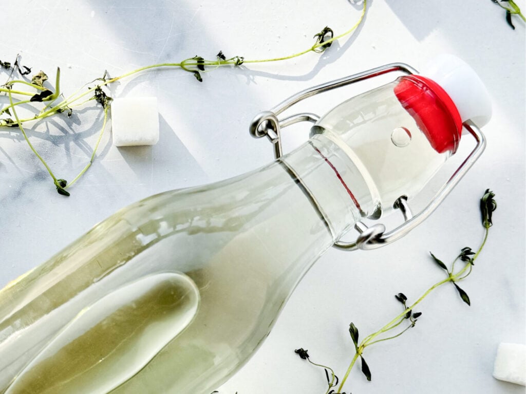 Photo of thyme infused simple syrup in a clean glass jar