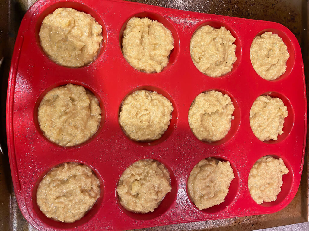 photo of Gluten Free Banana Nut bread batter resting in 12 muffin cups ready to go into the oven