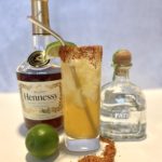 Hennessy margarita cocktail next to a bottle of Hennessy and Patron