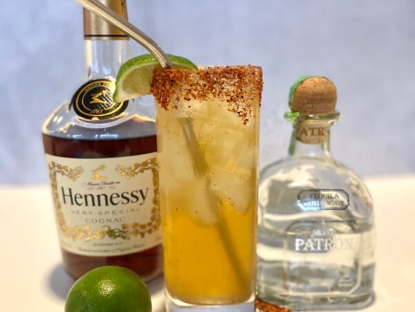 Hennessy margarita cocktail next to a bottle of Hennessy and Patron