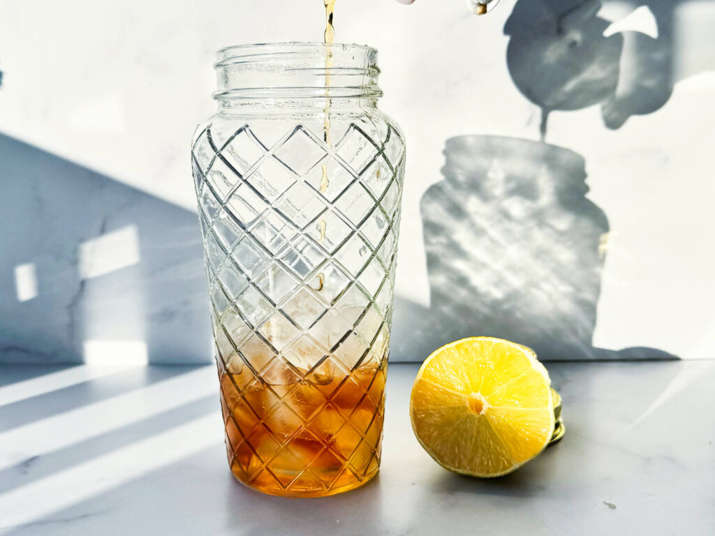 a photo of Hennessy being poured into a cocktail shaker
