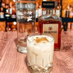 Photo of Vanilla Vodka and Disaronno Liqueur behind a glass of spiked eggnog
