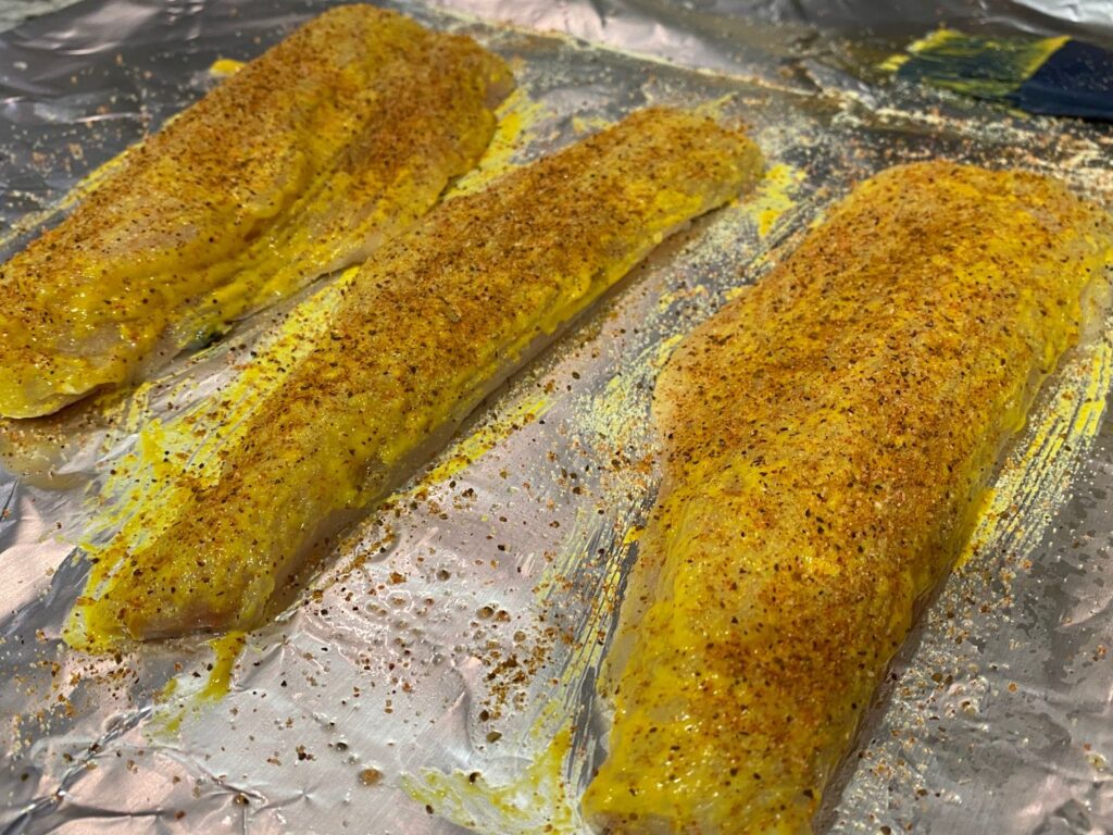 Photo of seasoned fish with seasoning and mustard