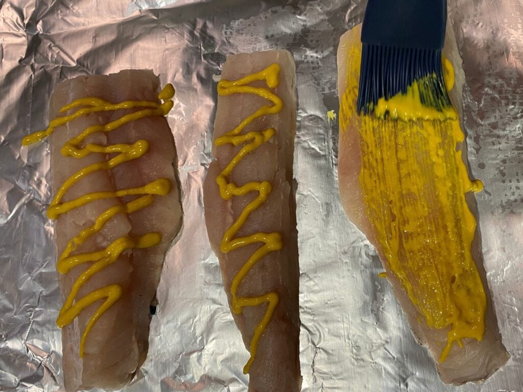Photo of coating fish with a brush and mustard