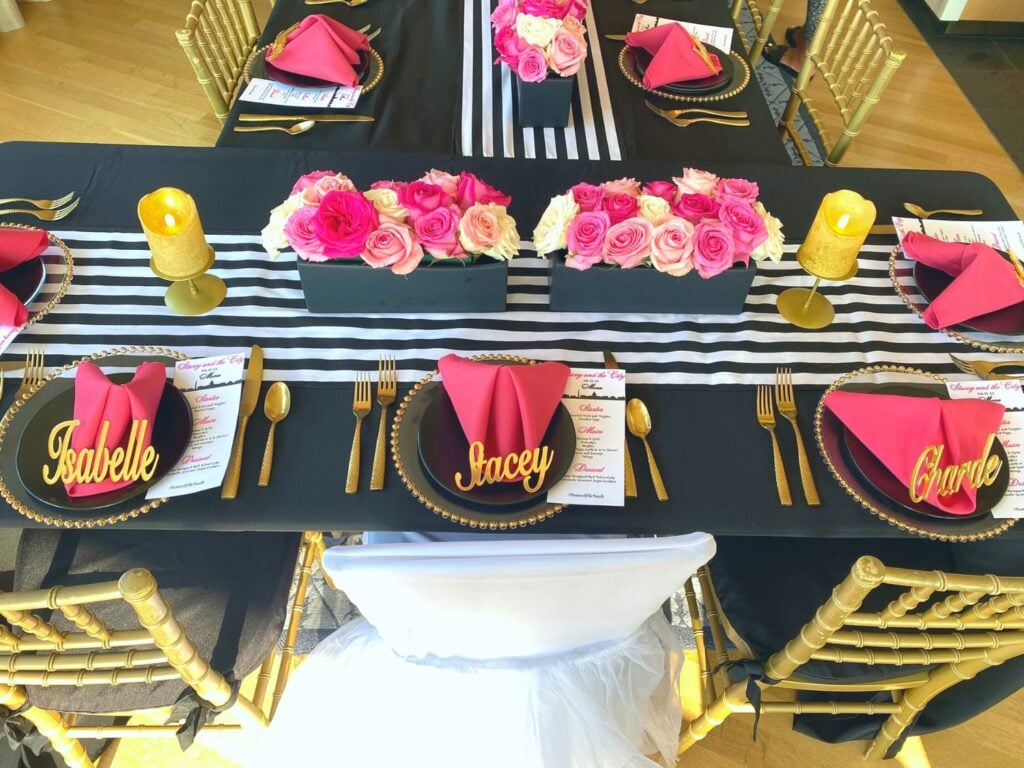 Photo of bridal shower table that's pink, black, white and gold with custom bride chair cover