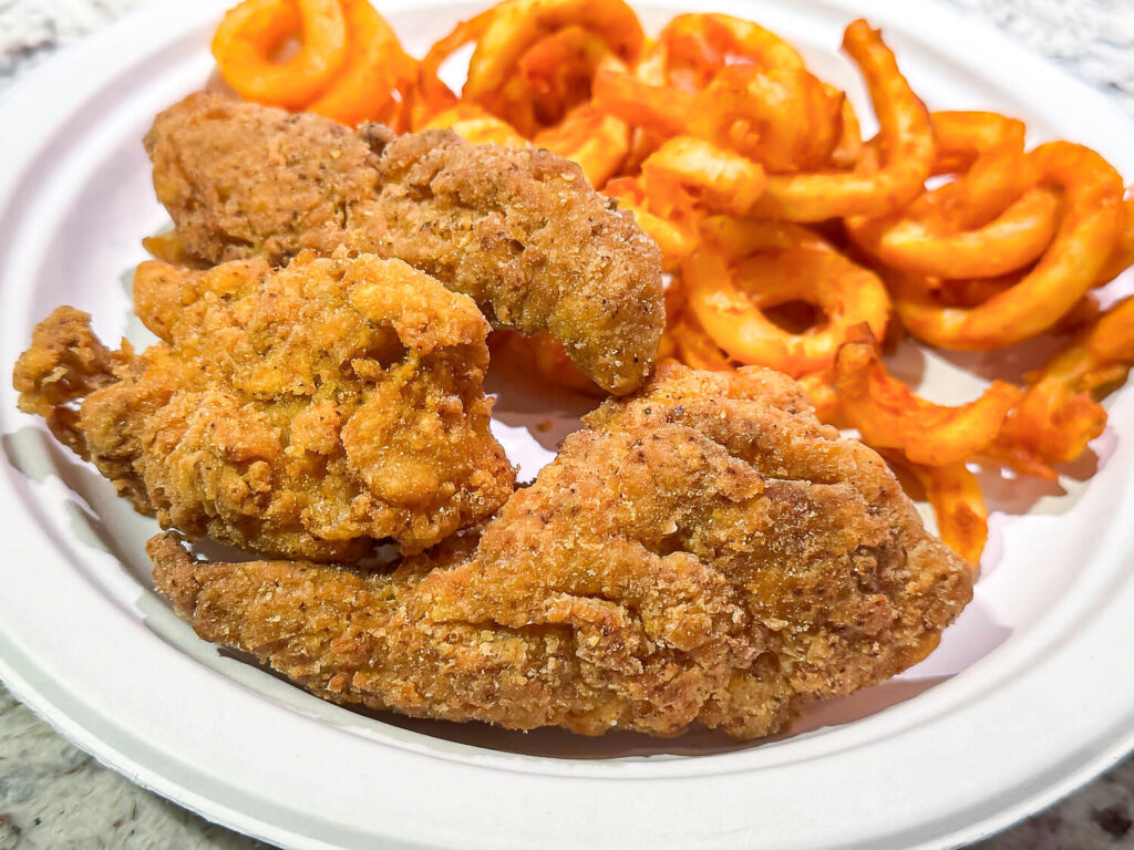 photo of fried fish and a plate of curly fries