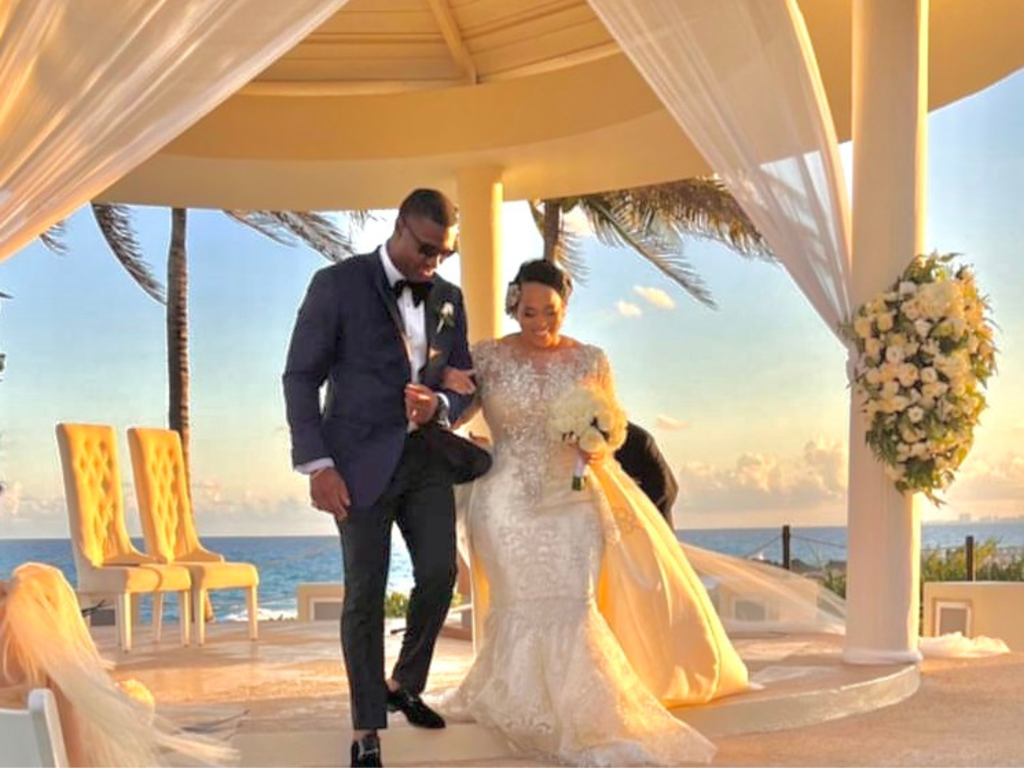 Photo of bride and groom leaving outdoor wedding at sunset