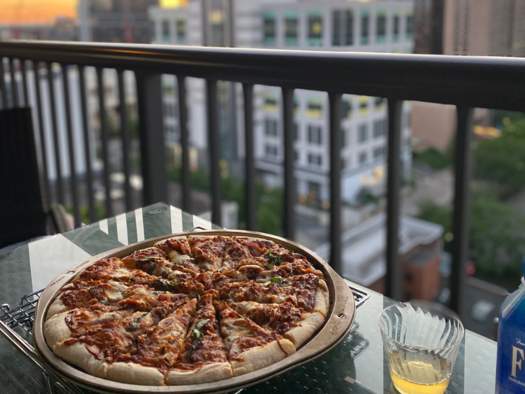 photo of a pizza on a table with a city in the background 