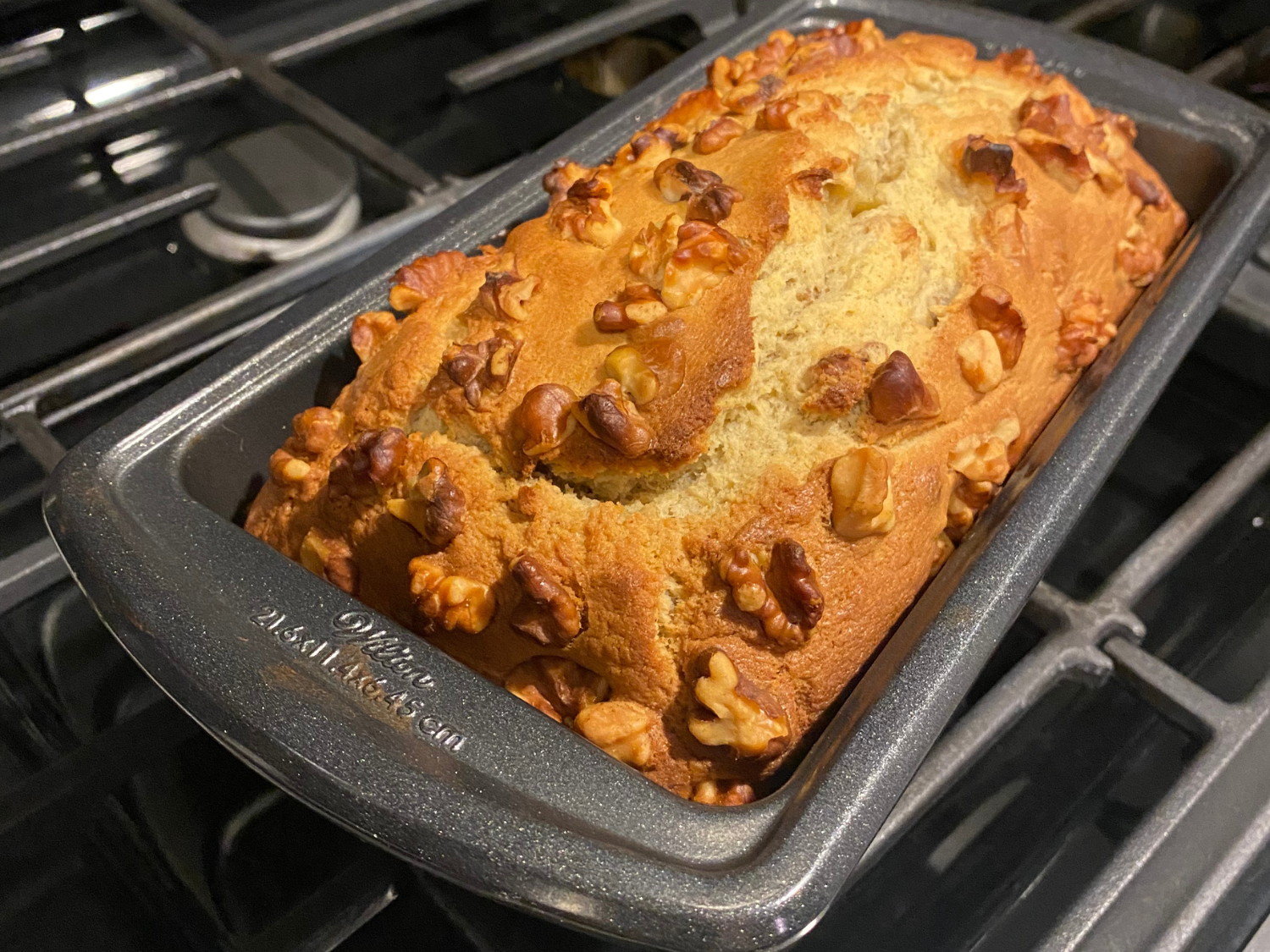 close up photo of baked banana nut bread out of the oven in a pan