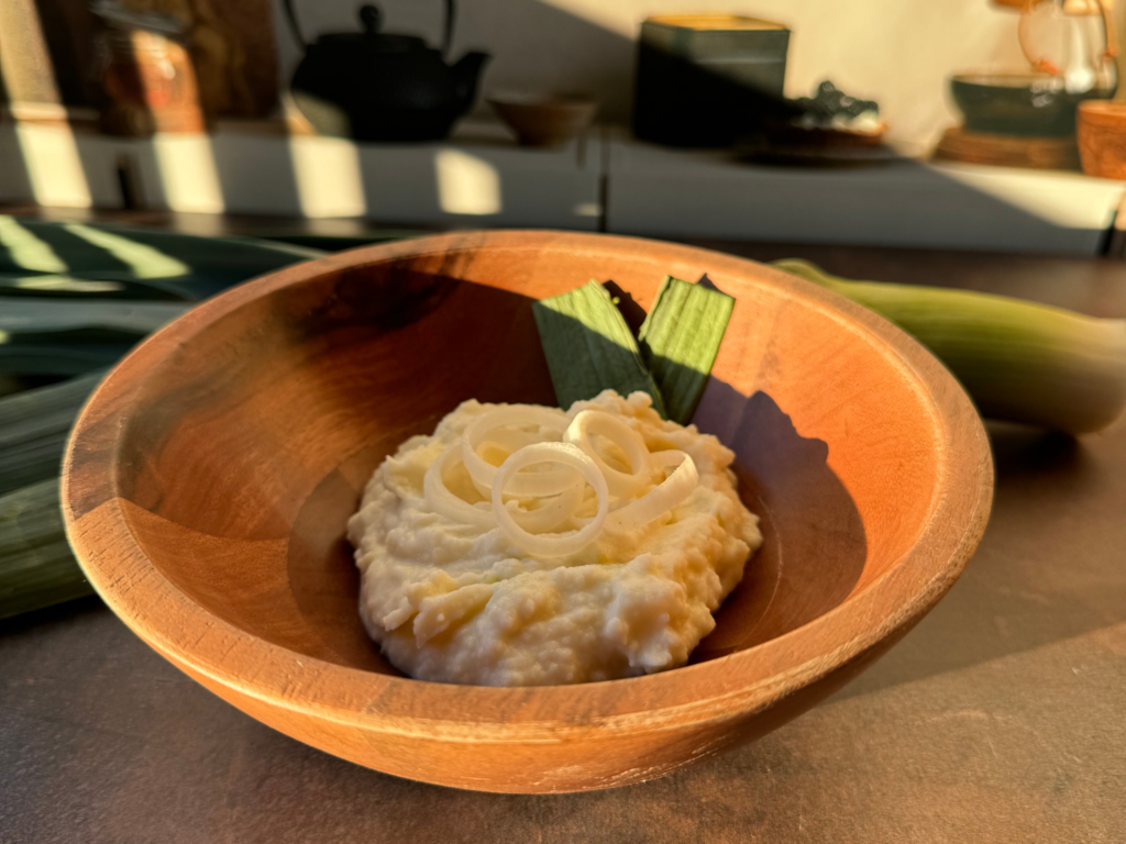 photo of sour cream and leek mashed potatoes in wooden bowl