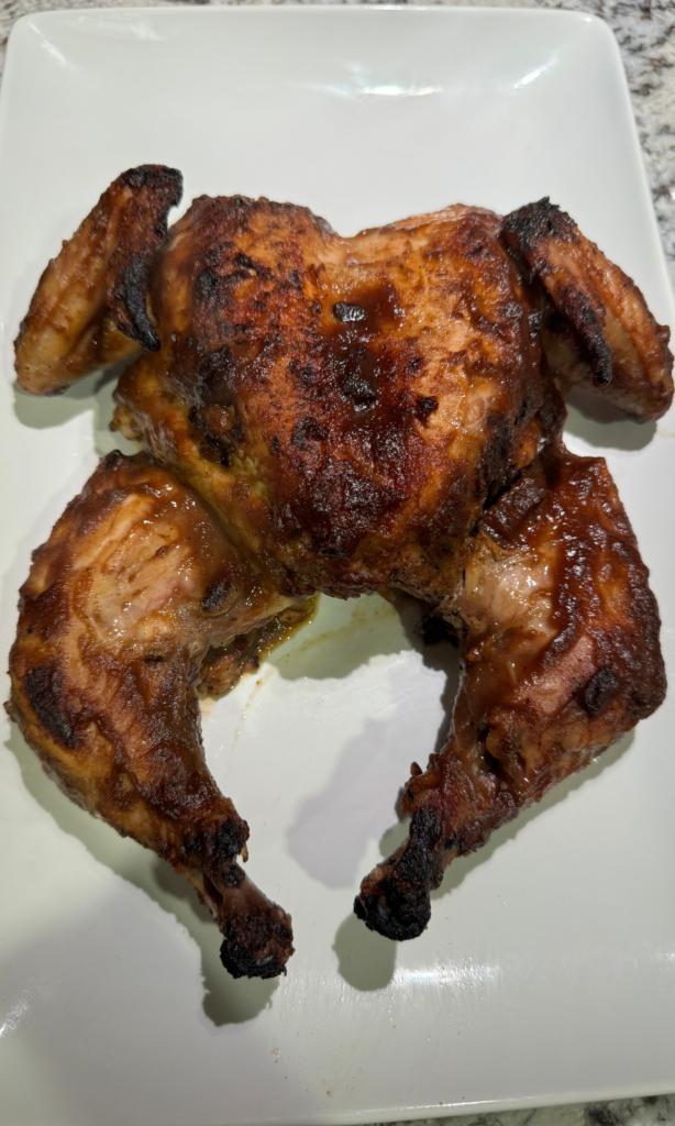 Photo of cooked apple butter chicken resting on a white plate