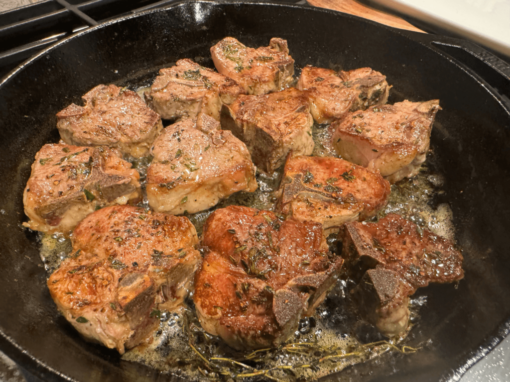 photo of lamb chop loins cooking in a cast iron pan