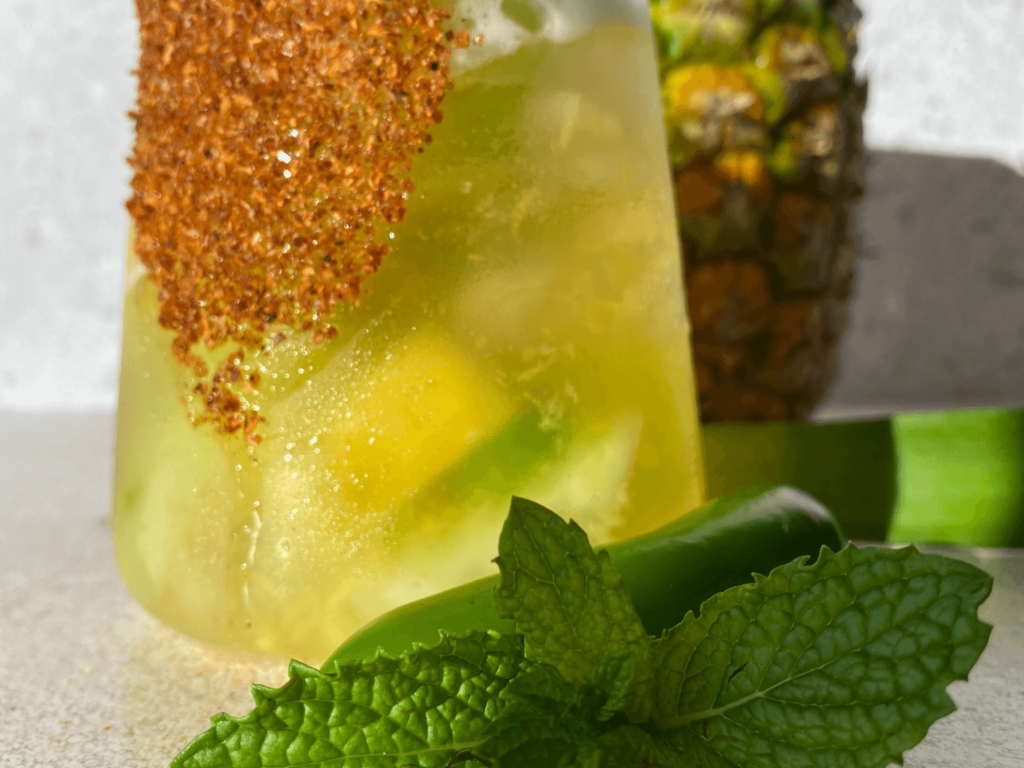 Photo of a spicy pineapple margarita with a mint garnish