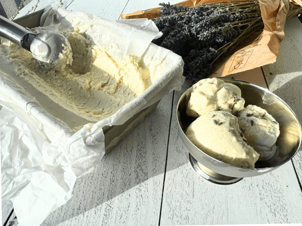 photo of lavender ice cream in a pan and bowl next to a bouquet of lavender