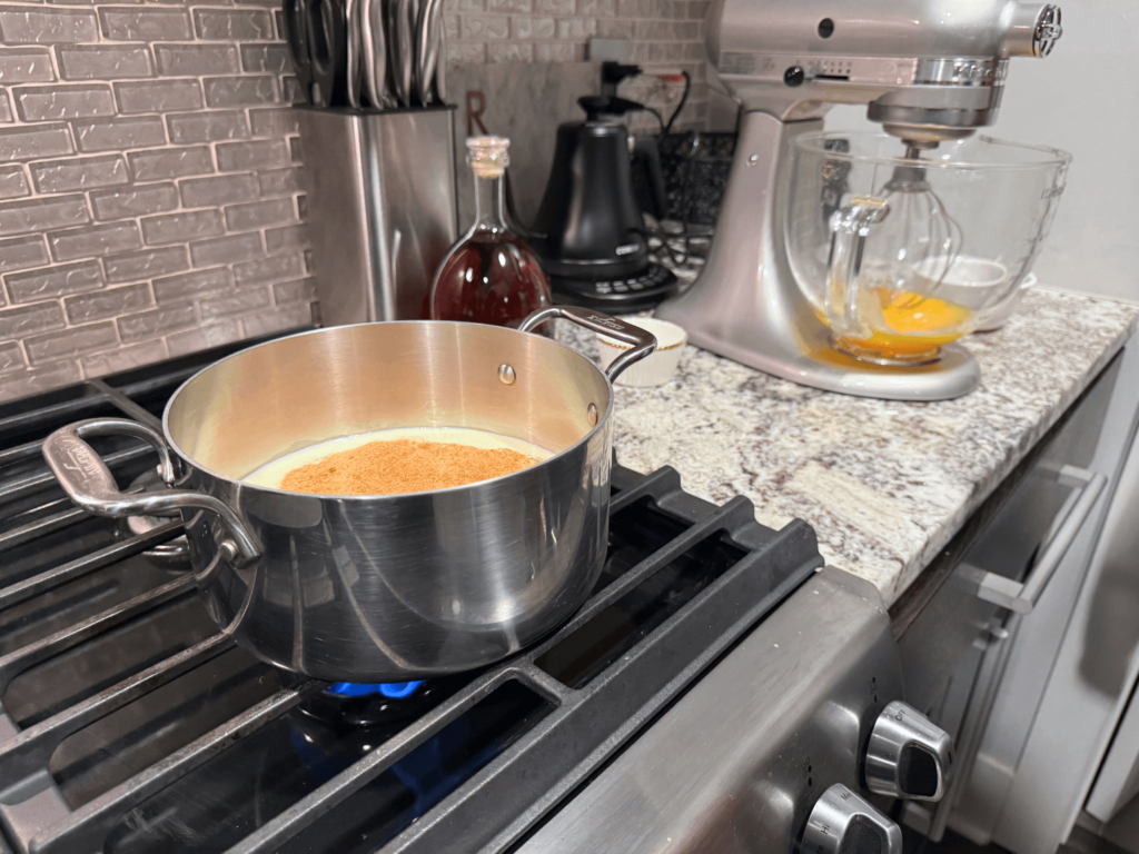 photo of milk and nutmeg mixture on stove top for homemade spiked eggnog recipe