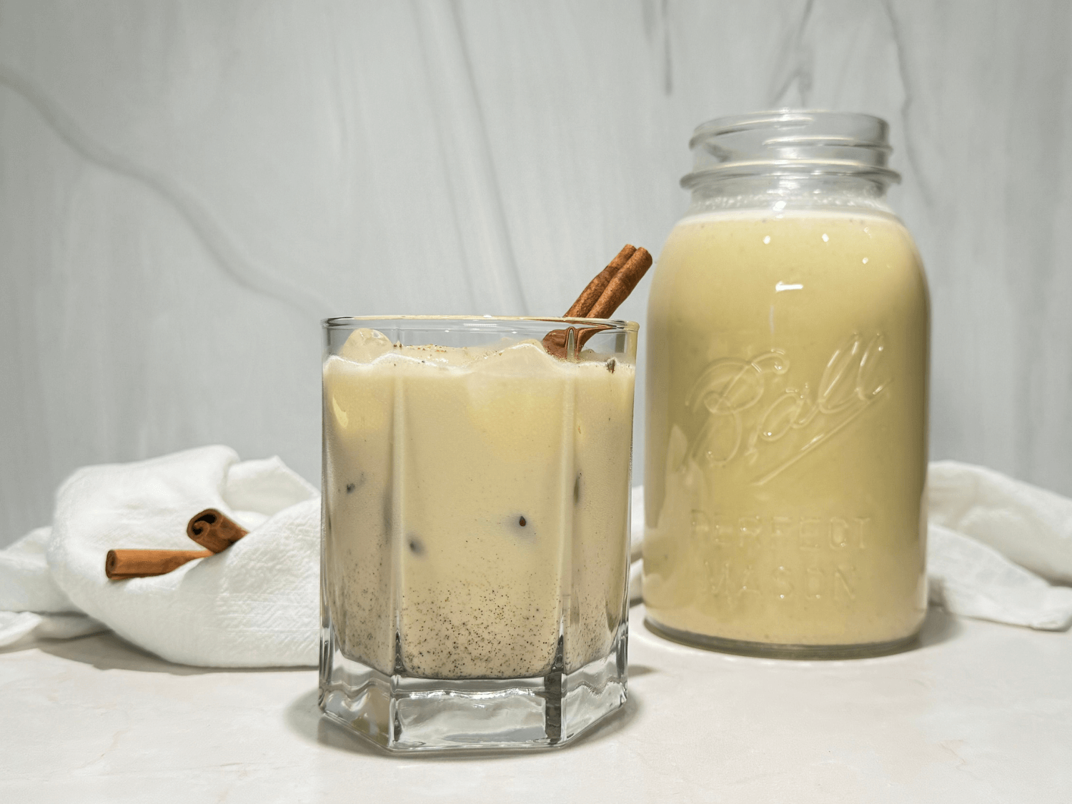 photo of homemade spiked eggnog in a glass and mason jar