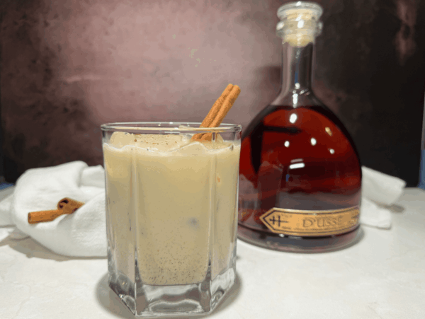 photo of homemade spiked eggnog next to a bottle of Dusse cognac