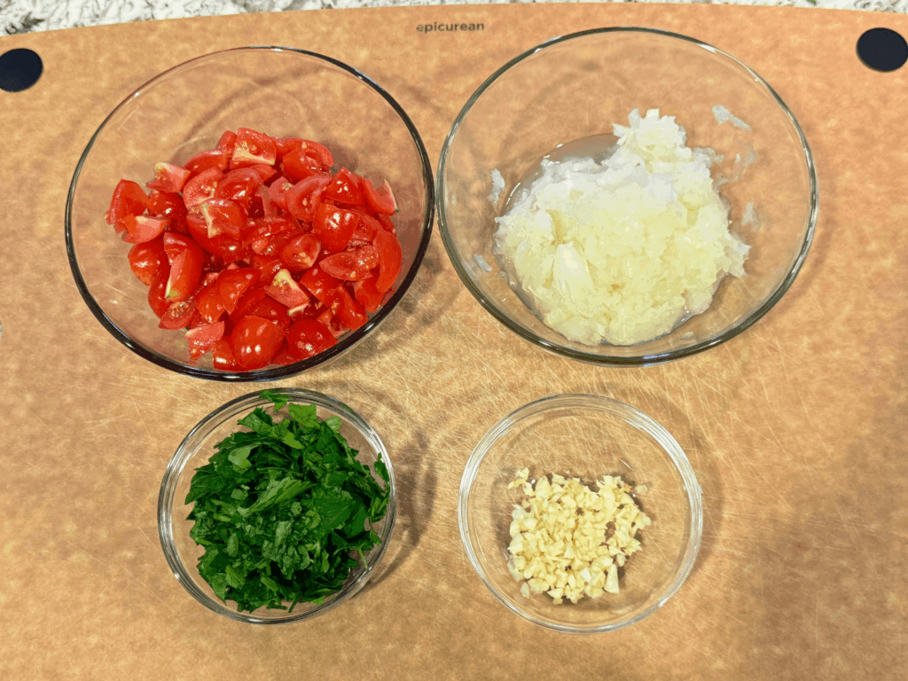 photo of chopped tomatoes, shredded onions, chopped parsley, and minced garlic for Turkish pasta recipe