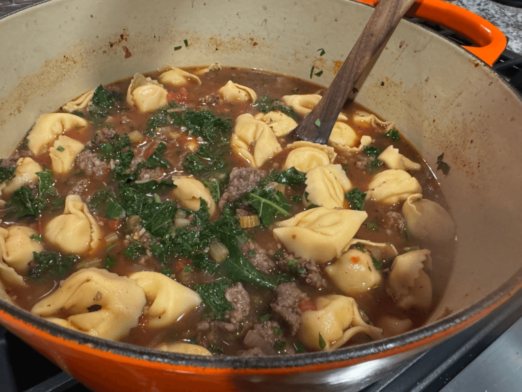 photo of tortellini soup with kale on top