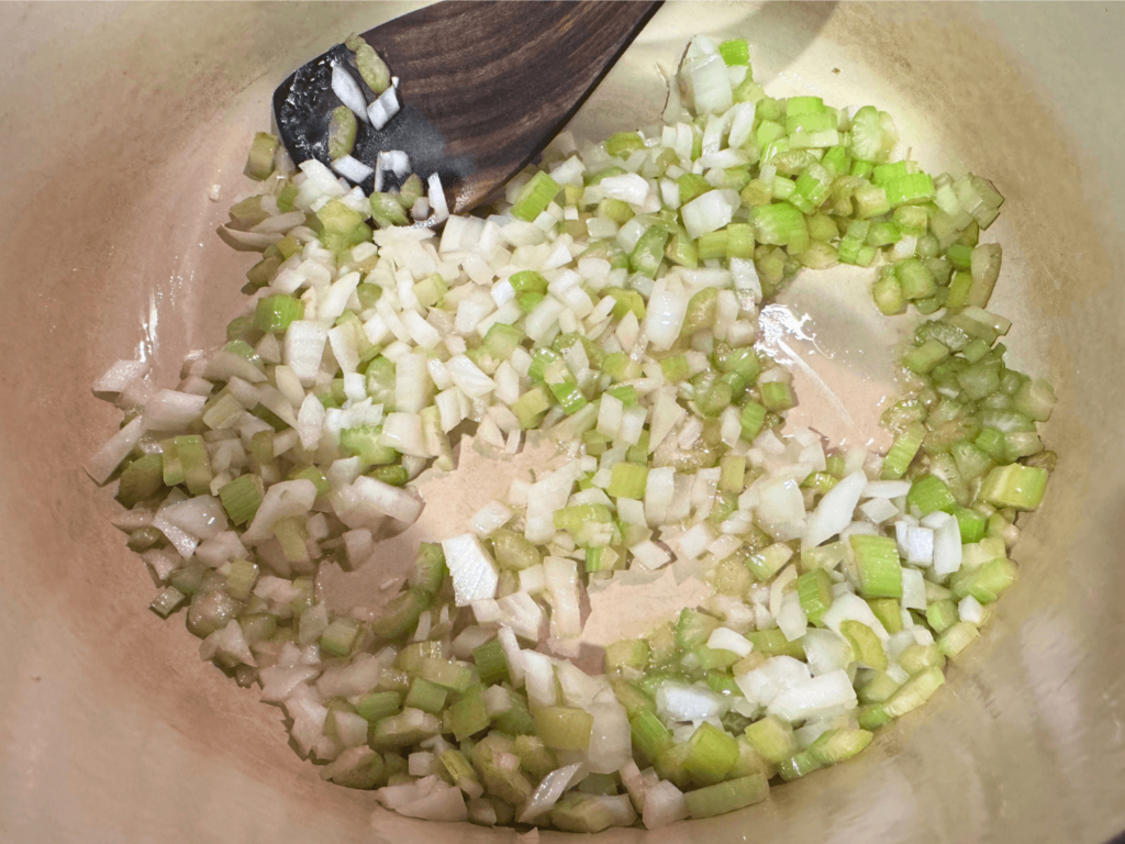 close up photo of onions and celery in a cooking pot for tortellini soup
