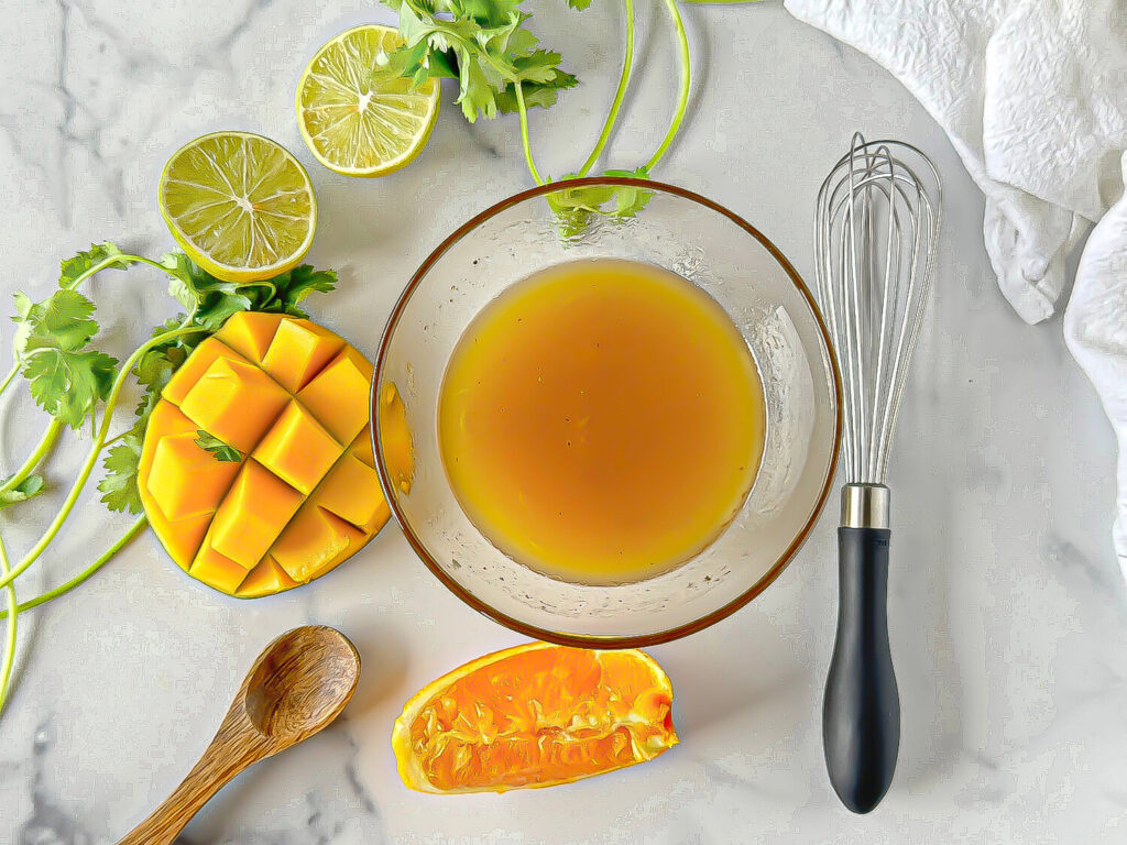 photo of marinade in a glass bowl next to a whisk