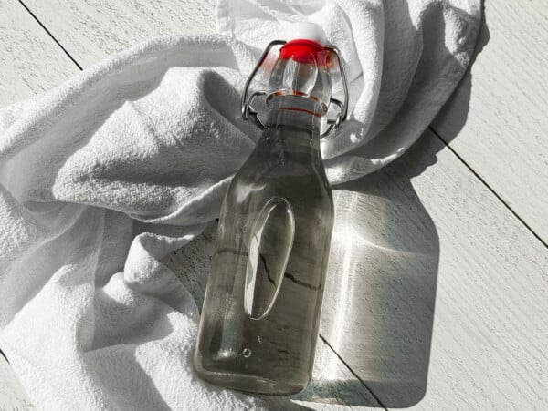 close up photo of an air tight container holding cooked simple syrup on a white towel