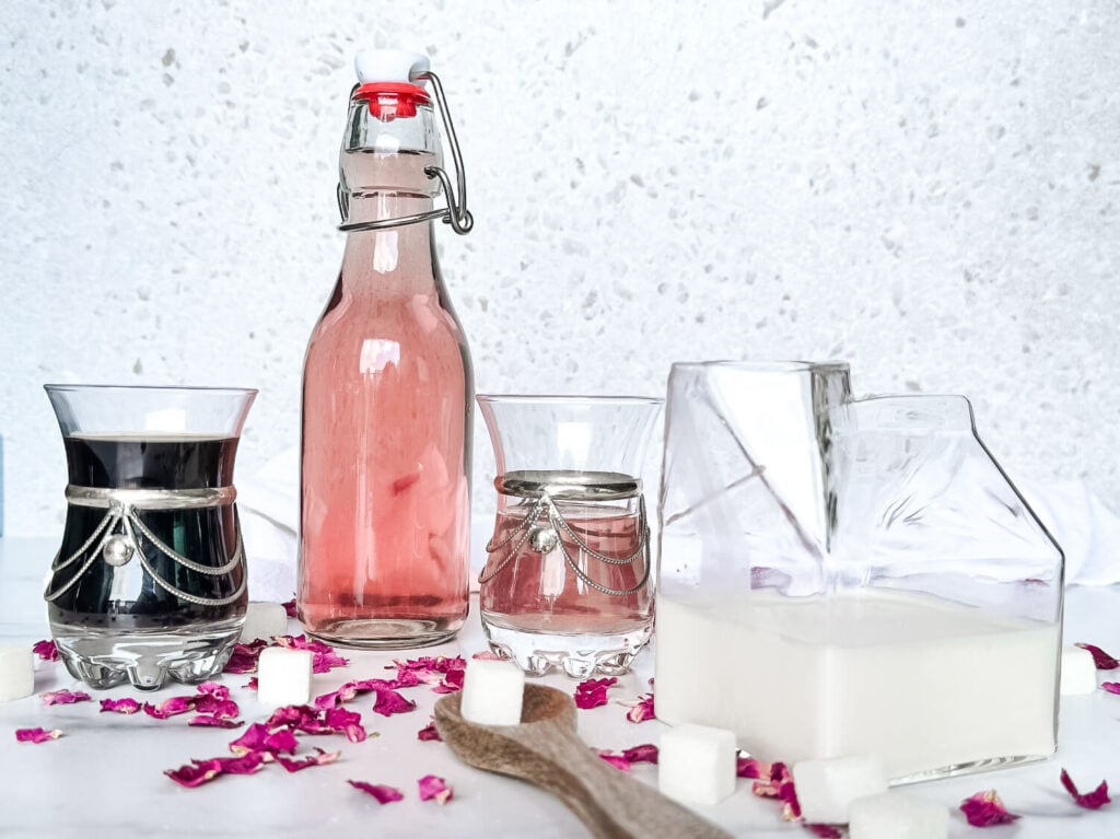 Photo of an iced rose latte ingredients: espresso, milk, and rose syrup