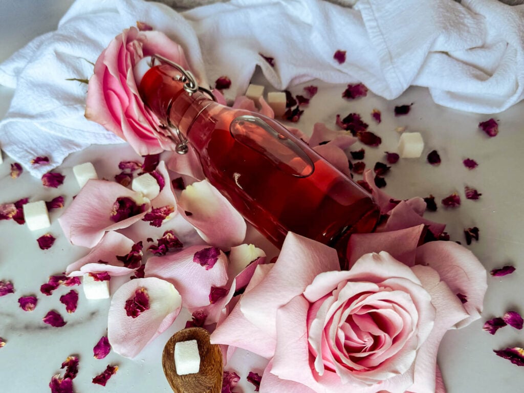 close up photo of rose simple syrup in airtight class container