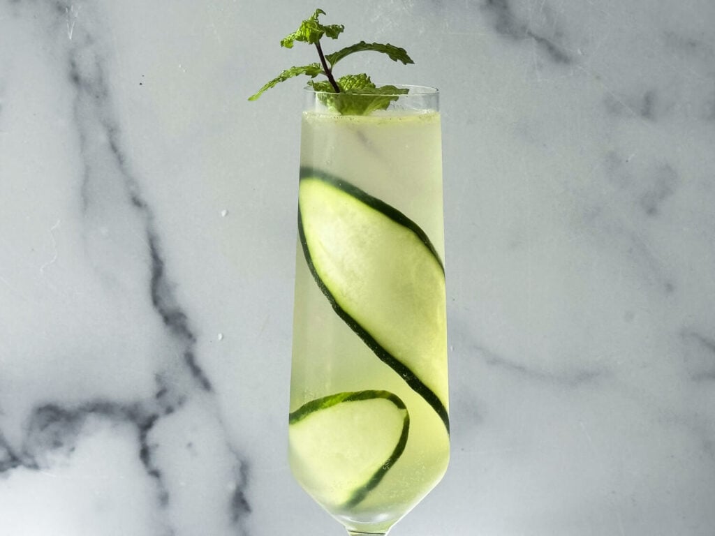 close up photo of the cucumber spritz cocktail in a champagne flute