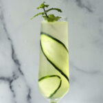close up photo of the cucumber spritz cocktail in a champagne flute