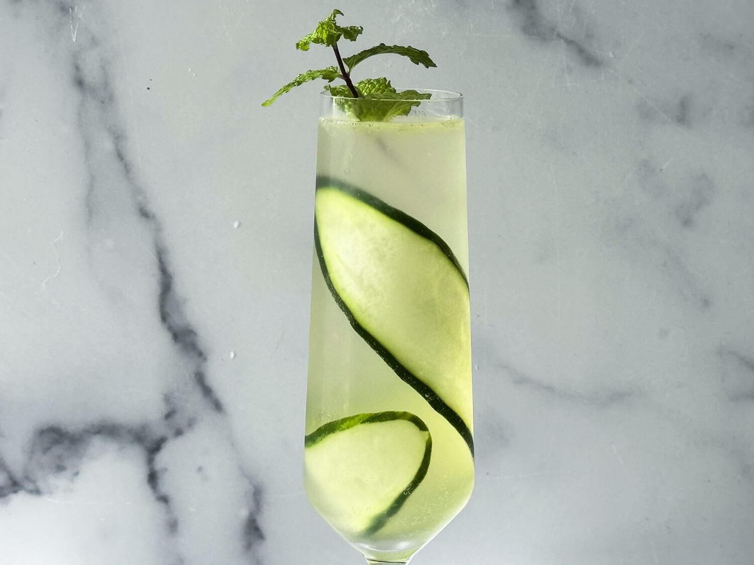 close up photo of the cucumber spritz cocktail in a champagne flute