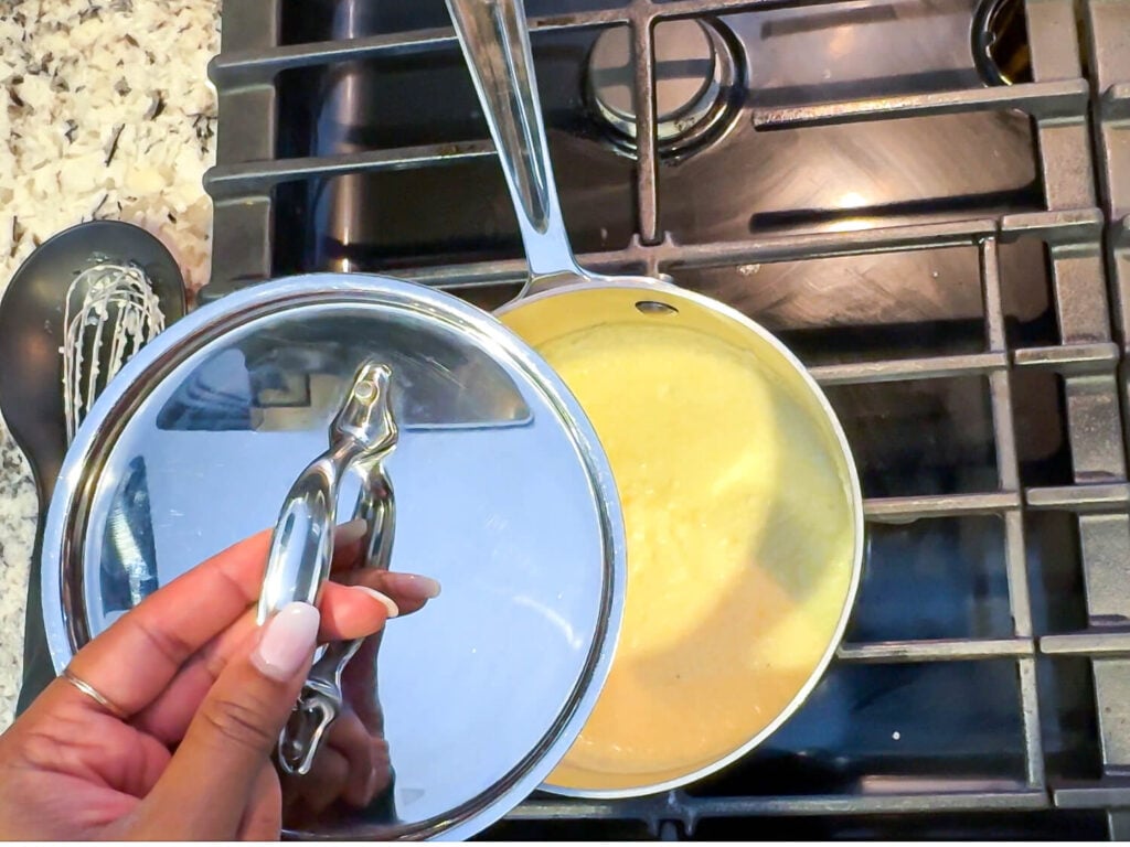 covering grits in a pot after cooking