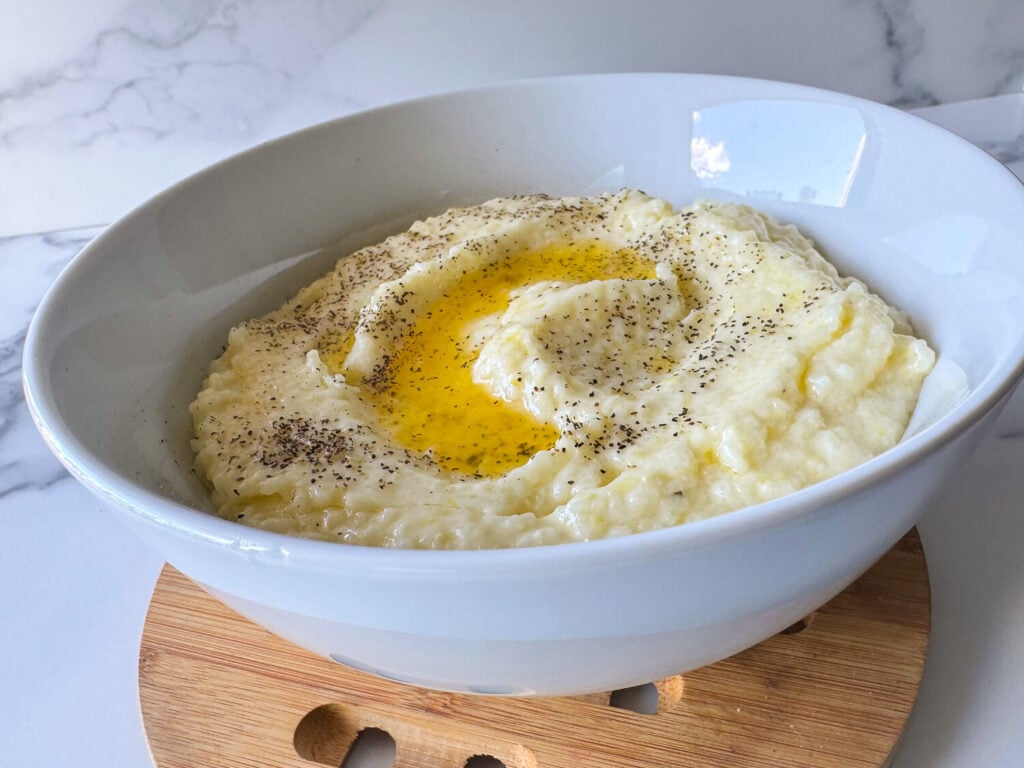photo of southern style grits in a white bowl with butter on top