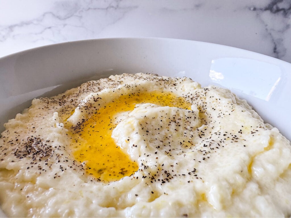 photo of southern style grits in a white bowl with butter on top