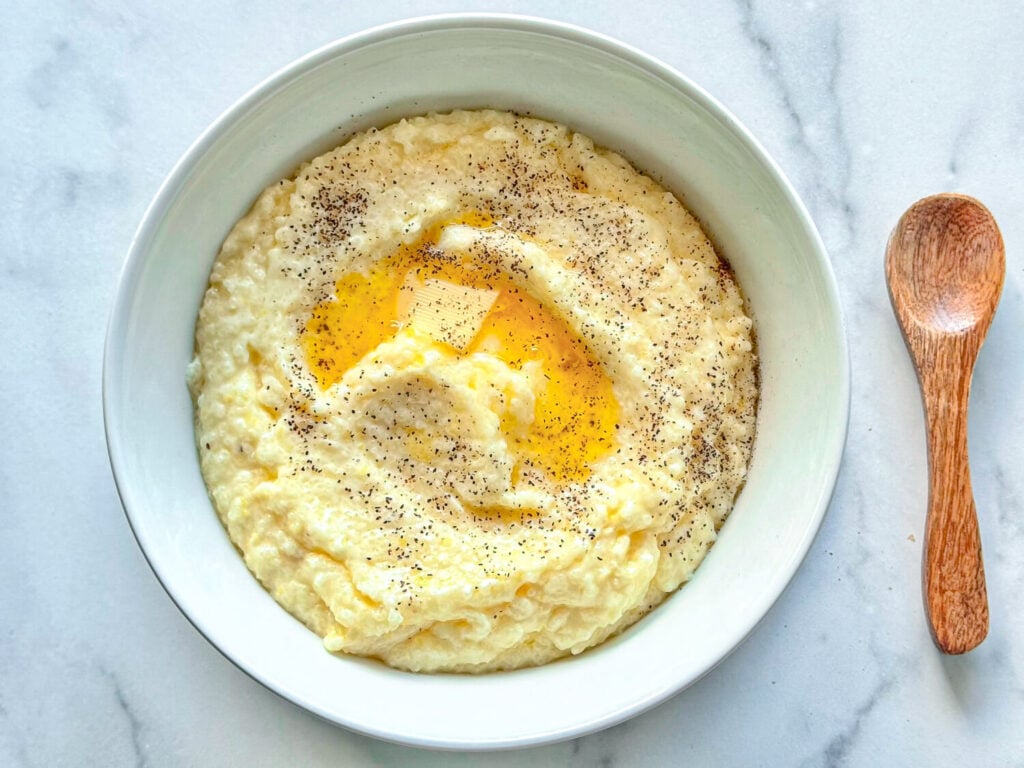 photo of southern style grits in a white bowl with butter on top