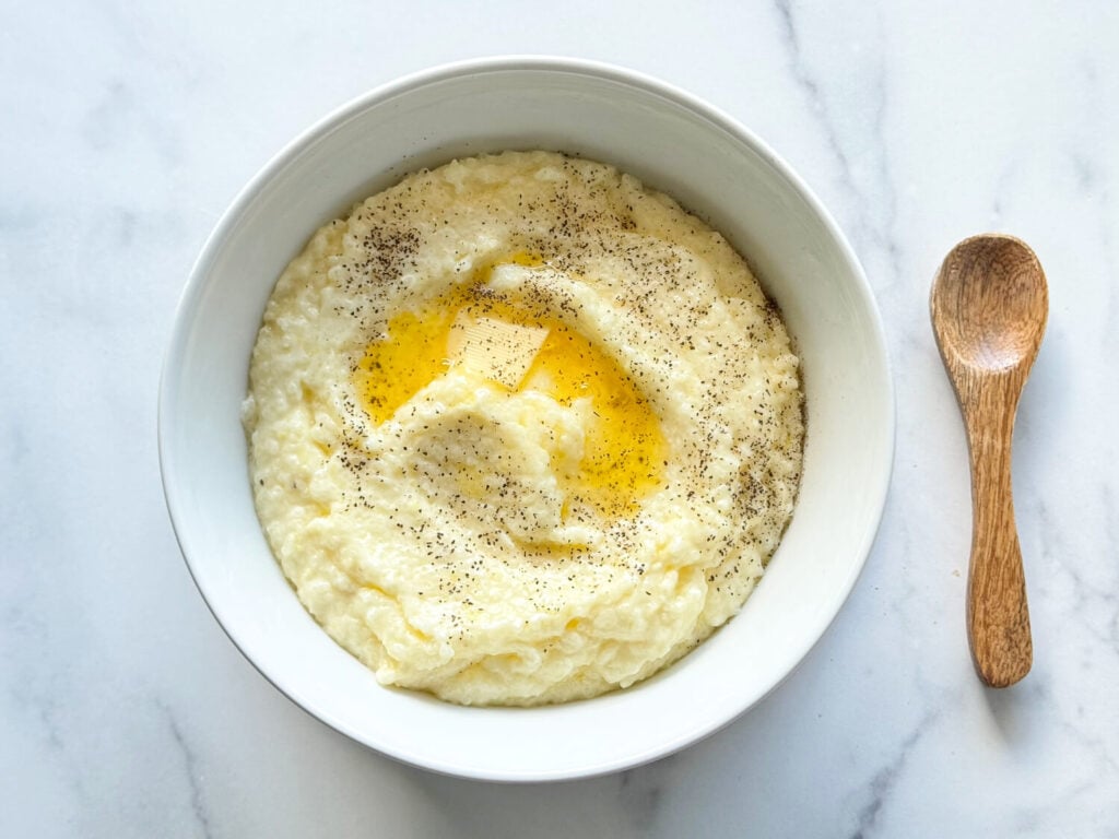photo of southern style grits in a white bowl with butter on top