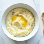 photo of southern style grits in a white bowl with butter on top