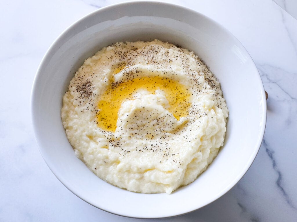 photo of southern style grits in a white bowl with butter on top