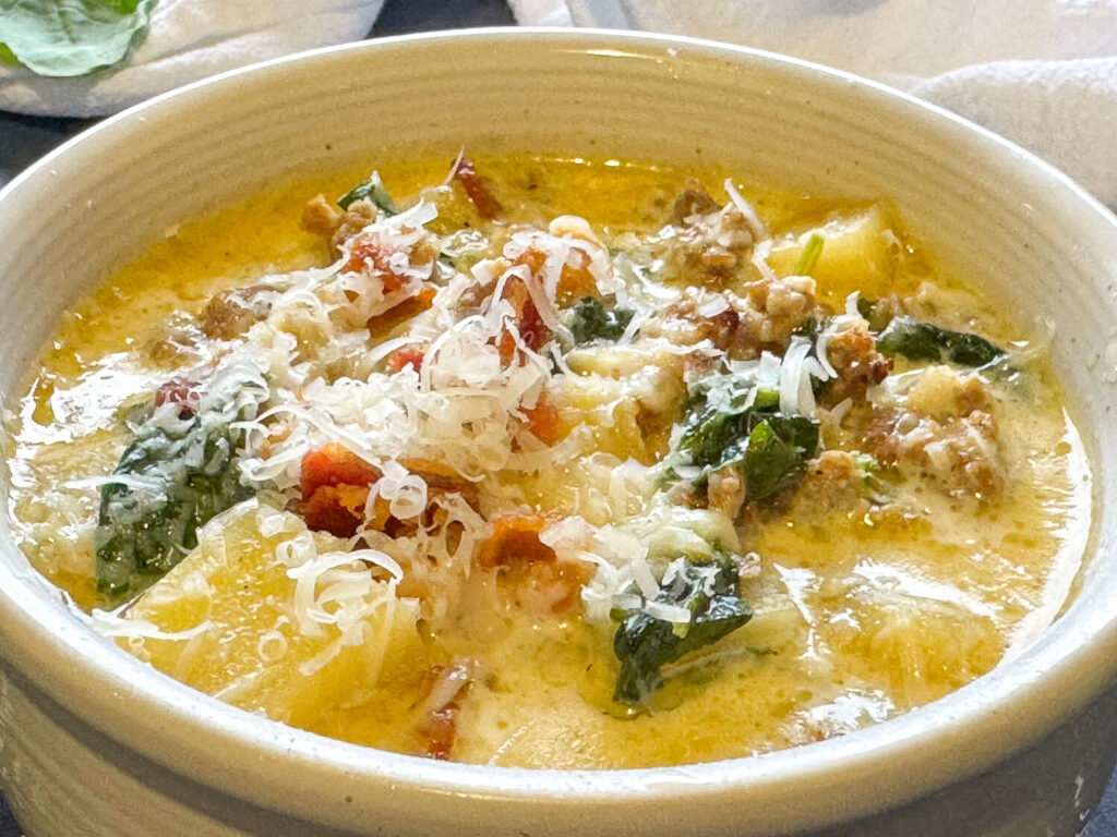 close up photo of Zuppa Toscana soup in a white soup bowl
