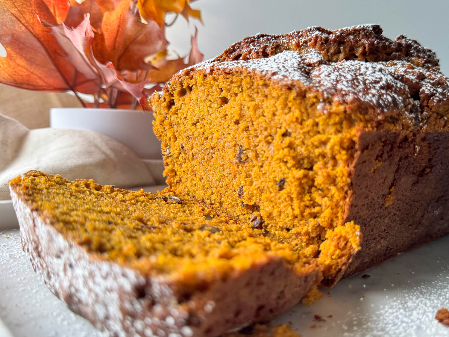close up photo of baked pumpkin bread topped with powedered sugar