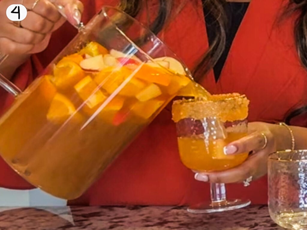 photo of elicit folio pouring apple cider sangria into a glass