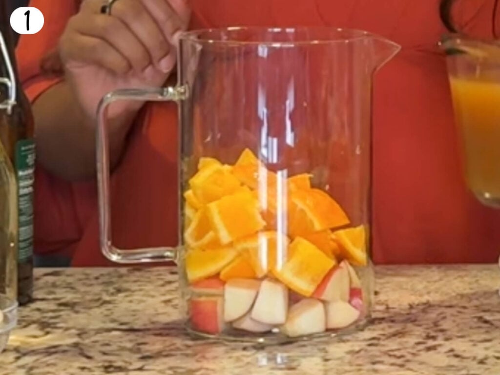 photo of a pitcher filled with apples and oranges
