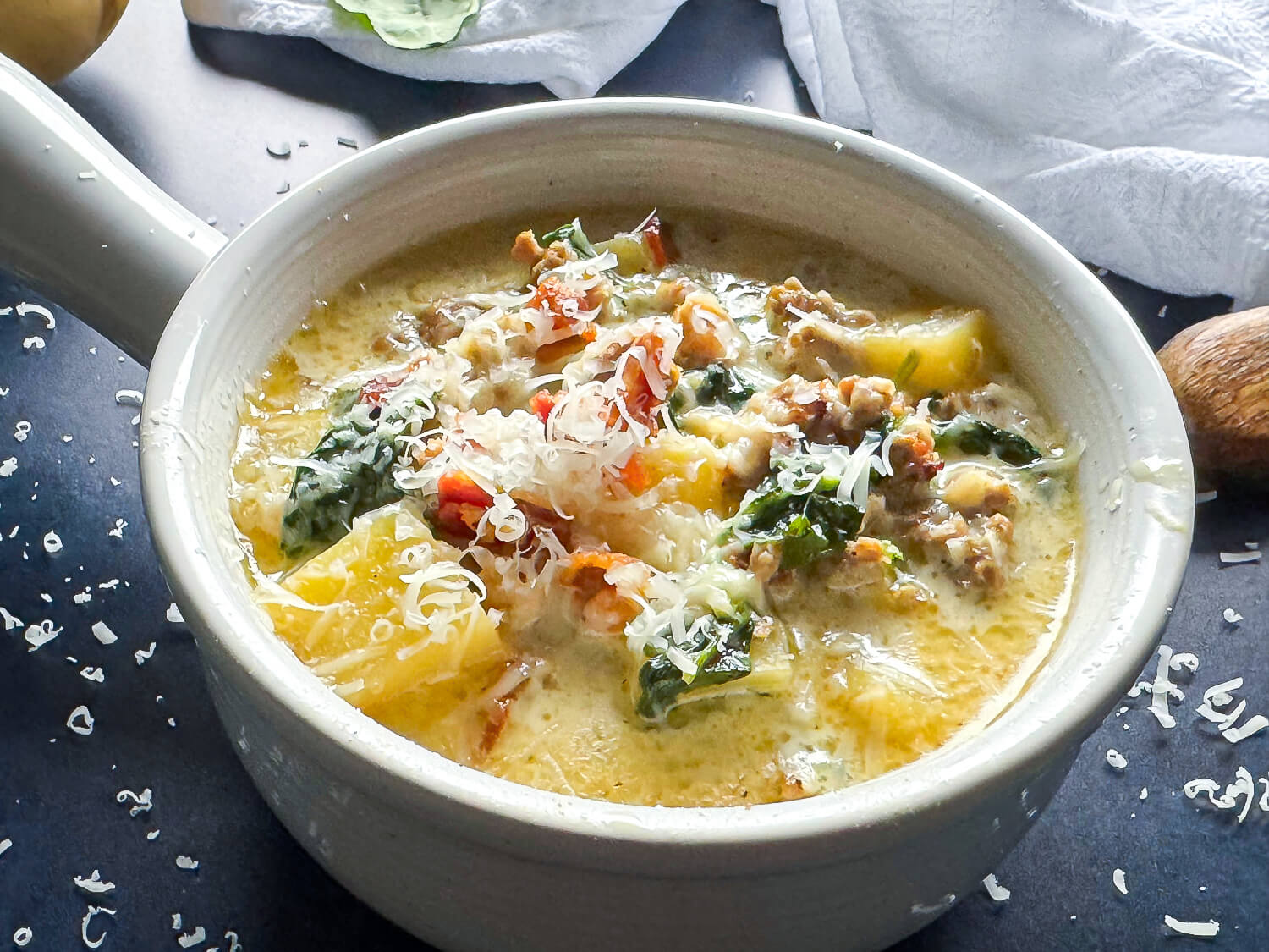 Zuppa Toscana Soup, the Olive Garden Copcat recipe in a soup bowl garnished with parmesan cheese and bacon