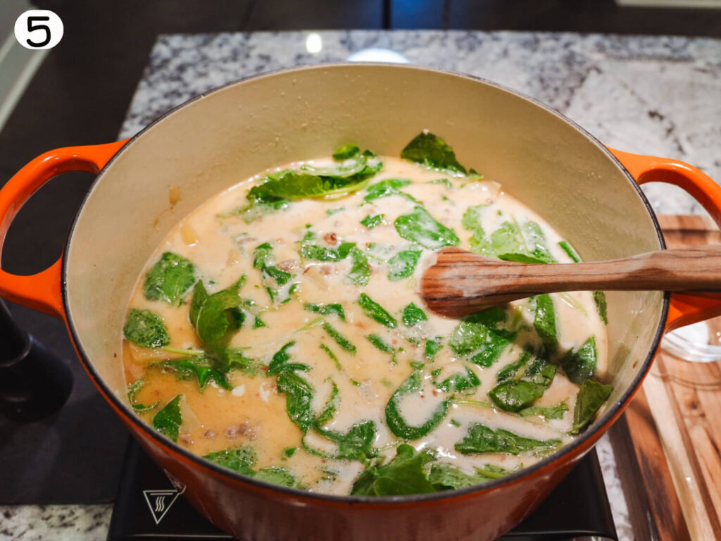 photo of cream and baby kale being added to the soup pot