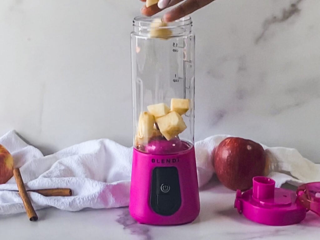 photo of chopped apples being added to a Blendi Pro + blender