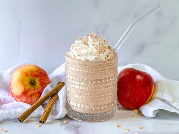 Photo of an apple smoothie next to apples