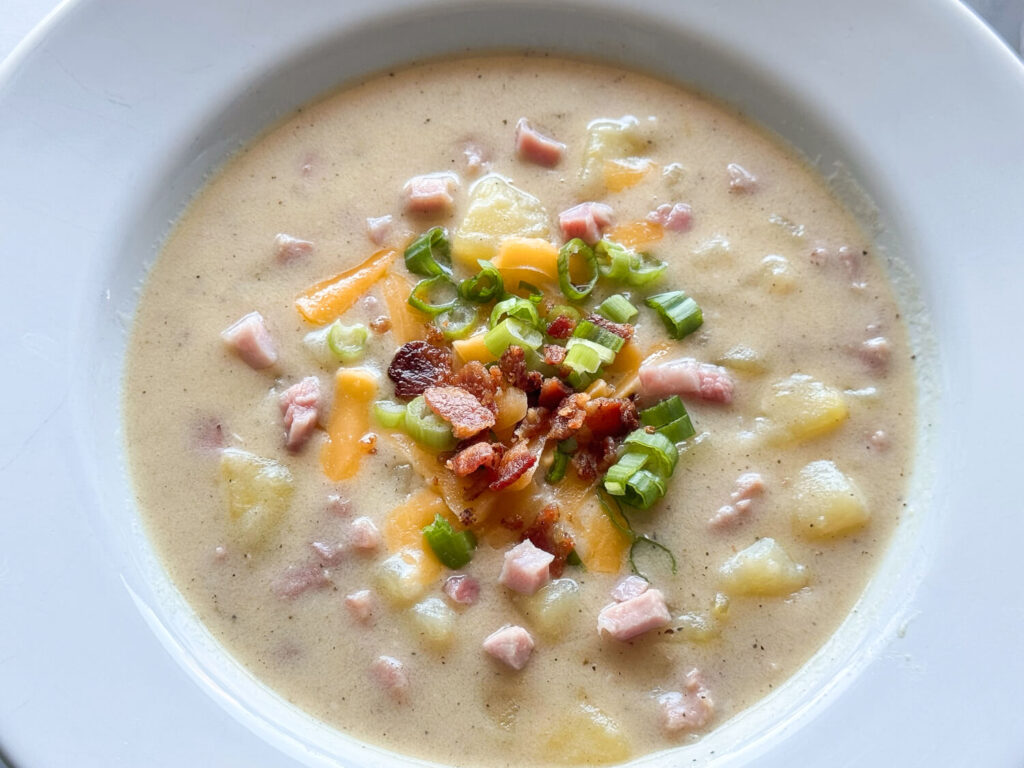 photo of ham and potato soup in a white bowl